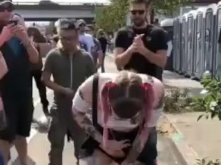 Girl pissing upon another girl in front of many people in the concert